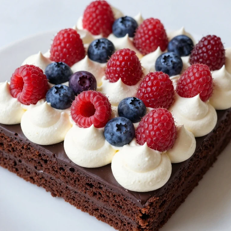 Chocolate sheet cake topped with whipped cream and fresh raspberries and blueberries