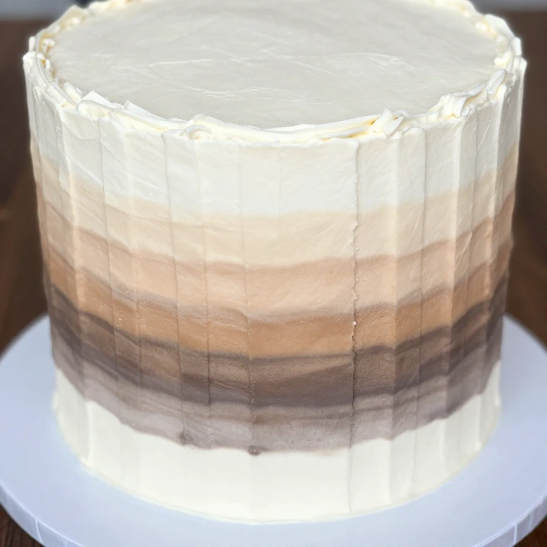 Modern layer cake with ombré buttercream stripe gradient design from light to dark