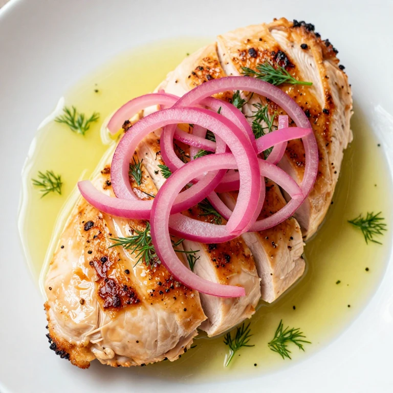 Golden seared chicken breast topped with bright pink pickled onions and fresh dill
