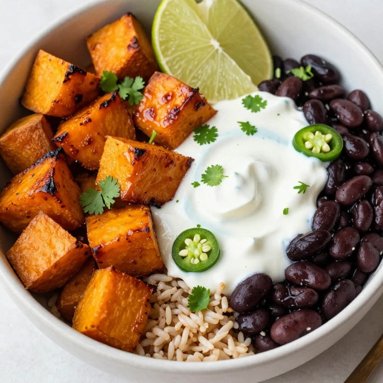 Black bean and sweet potato bowl with lime crema, cilantro, and lime wedges