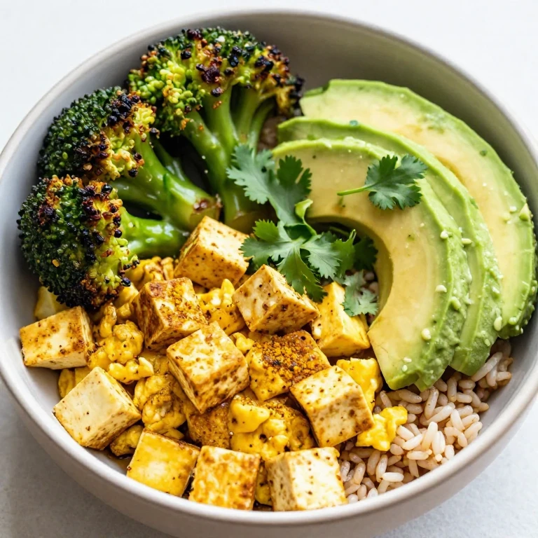 Tofu scramble and roasted broccoli bowl with brown rice, avocado, and cilantro