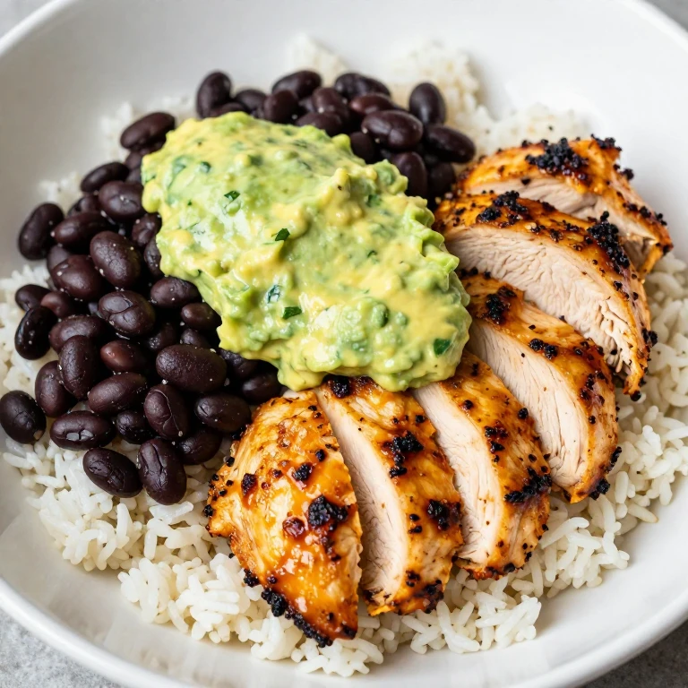 Sliced chipotle chicken with black beans, rice, and avocado crema