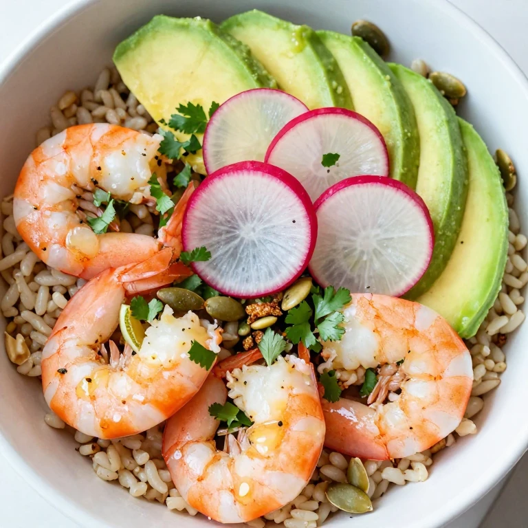 Citrus shrimp and avocado bowl with radishes, cilantro, and pumpkin seeds on brown rice