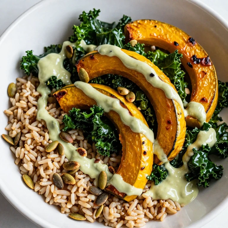 Miso-roasted squash and kale bowl with tahini sauce and pumpkin seeds over brown rice