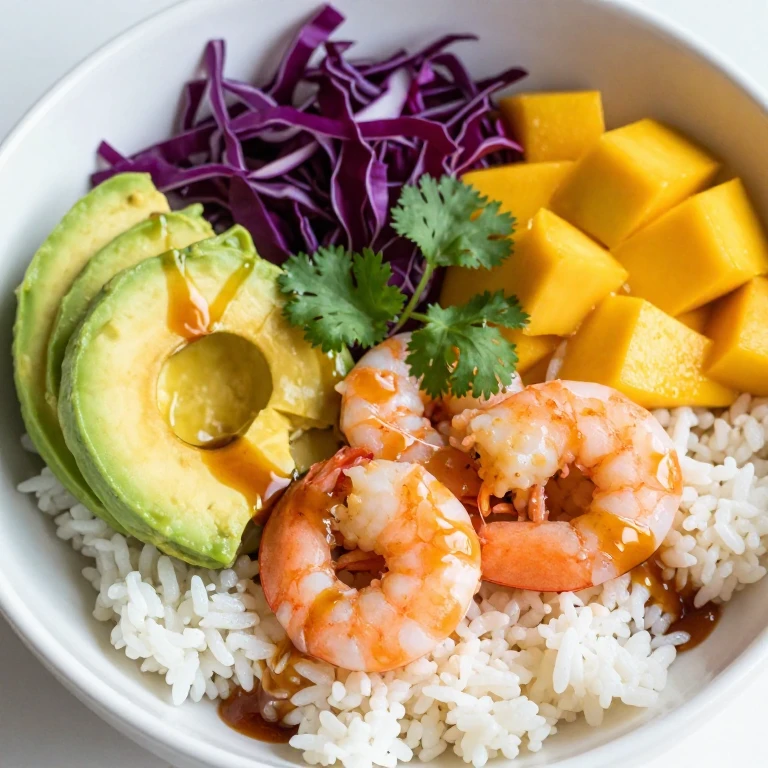 Citrus shrimp rice bowl with avocado, red cabbage, and mango
