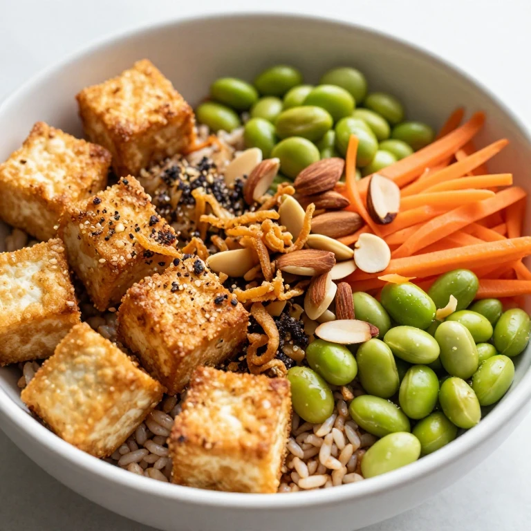 Crispy tofu rice bowl with edamame, carrots, almonds, and fried onions