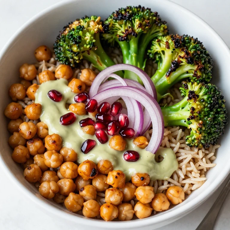 Chickpea tahini rice bowl with roasted broccoli, red onion, and pomegranate