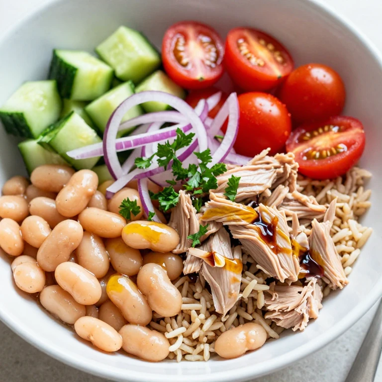 Tuna white bean rice bowl with cherry tomatoes, cucumber, and parsley