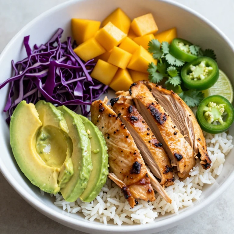 Rotisserie chicken rice bowl with avocado, purple cabbage, mango, and jalapeño