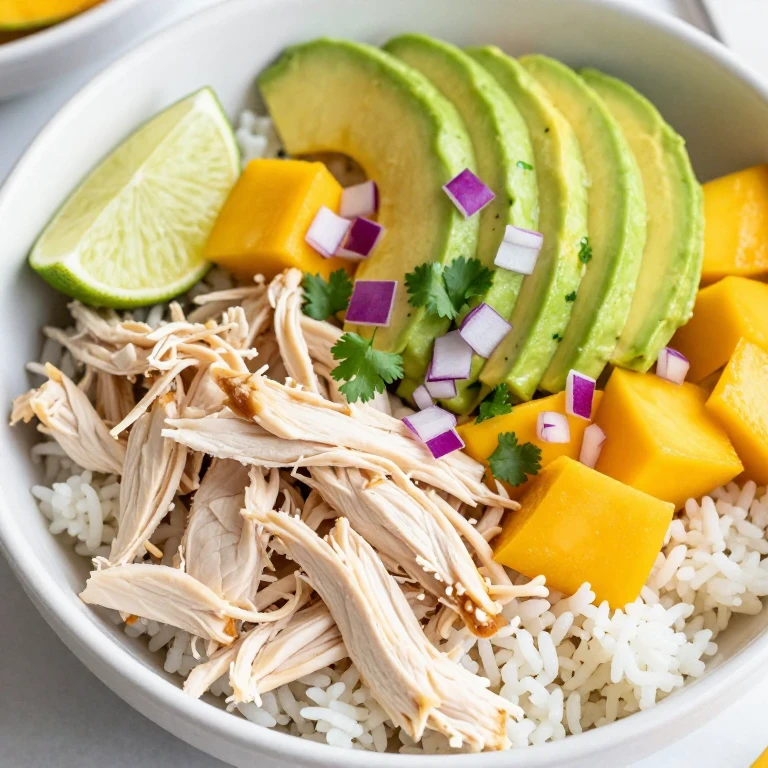 Mango chicken avocado rice bowl with cilantro, red onion, and lime wedge