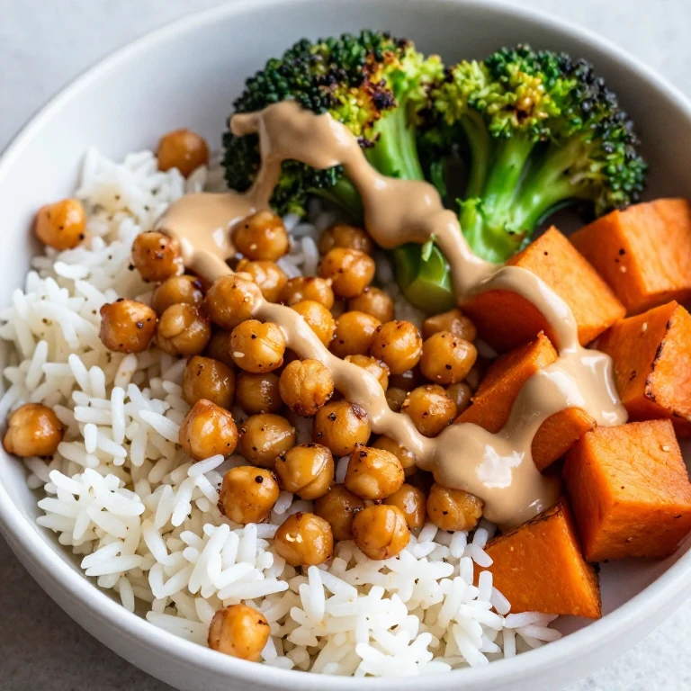 Spiced chickpea roasted vegetable rice bowl with tahini drizzle