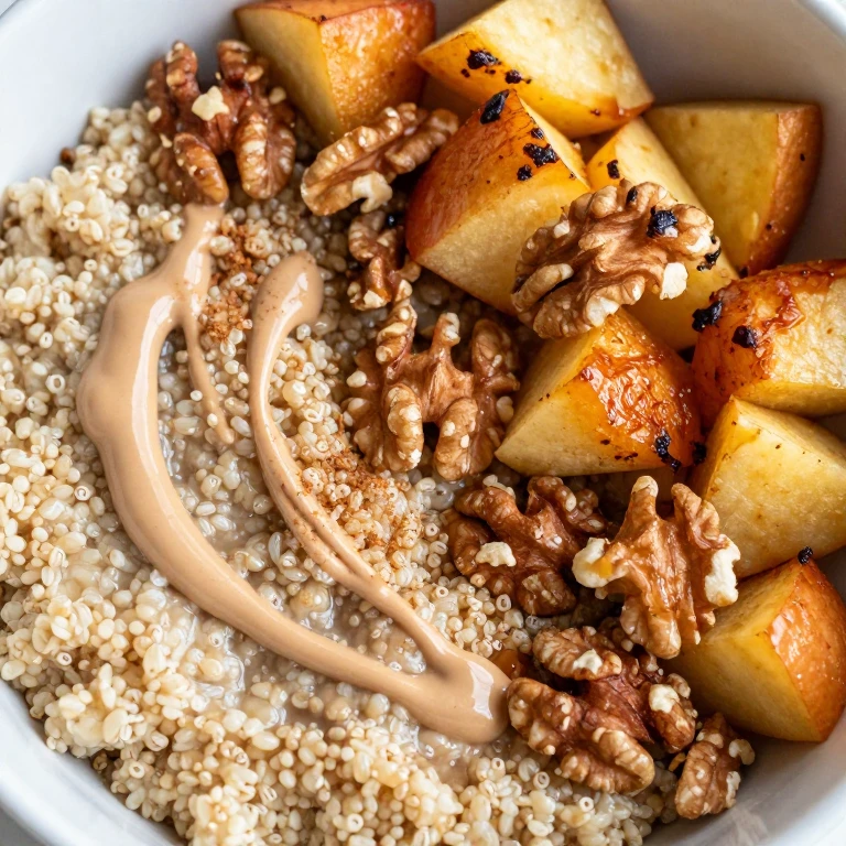 quinoa breakfast bowl with roasted apples, walnuts, and tahini drizzle